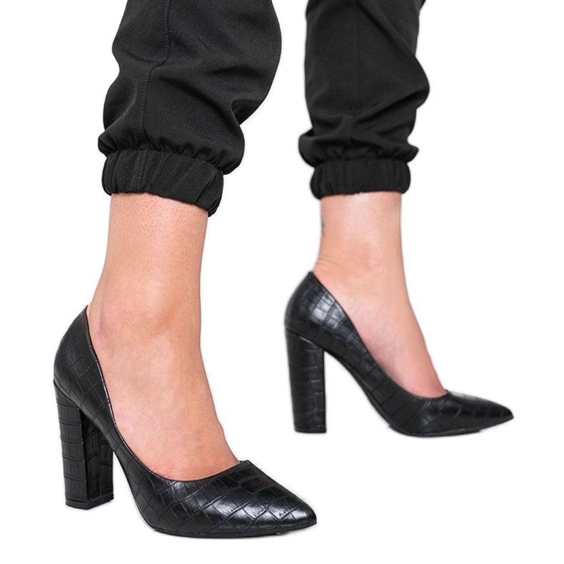 Mustat pumput pylväässä, jossa on käärmeen ihon kuvio tällä tavalla