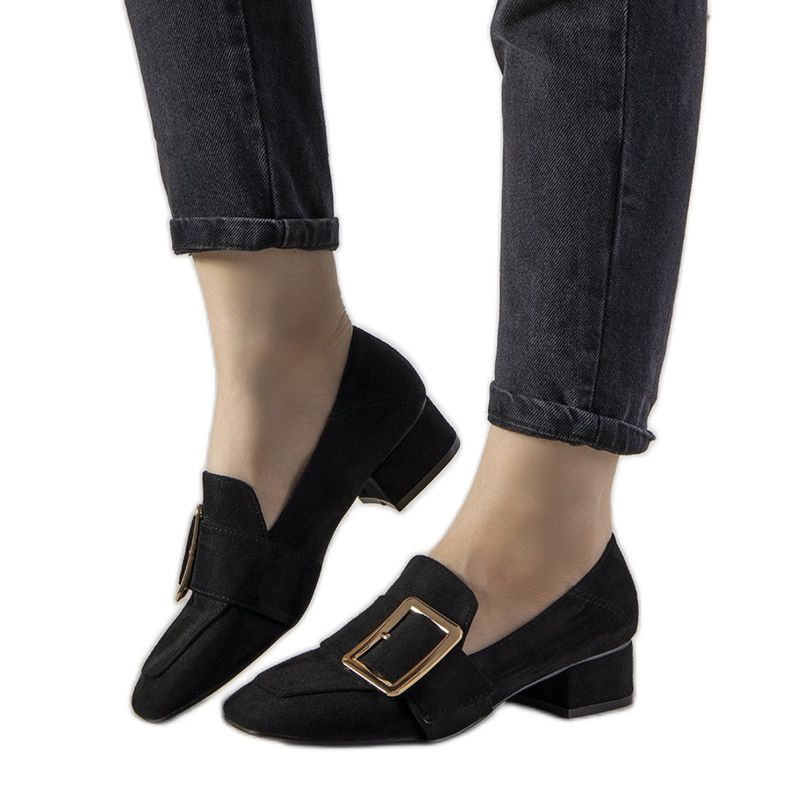 Mustat pumput pylväässä, jossa on seuraava solki