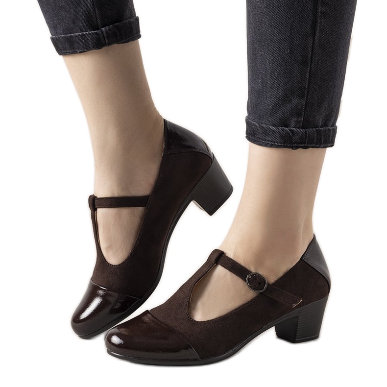 Ruskeat pumput pylväässä, jossa on lakattu jälkiruoka varvas