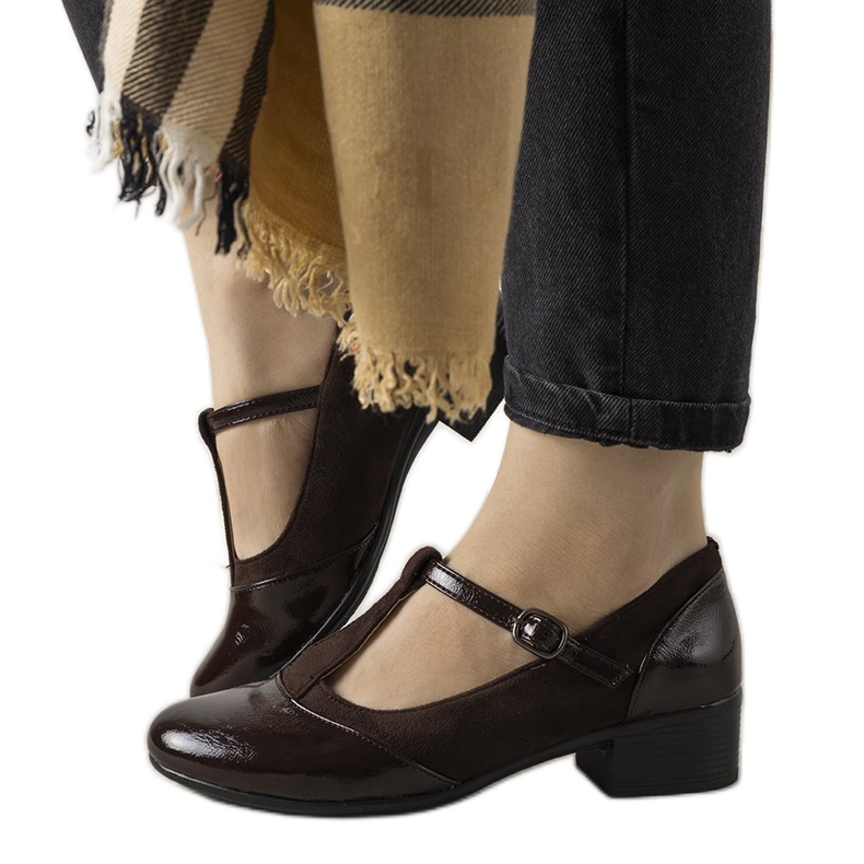 Ruskeat pumput pylväässä, jossa on lakattu Manam -varvas