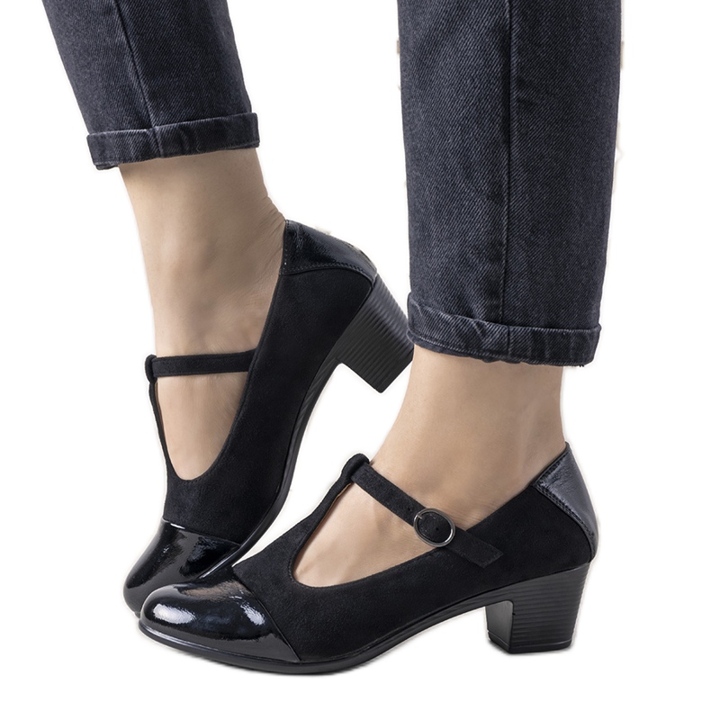 Mustat pumput pylväässä, jossa on lakattu jälkiruoka varvas