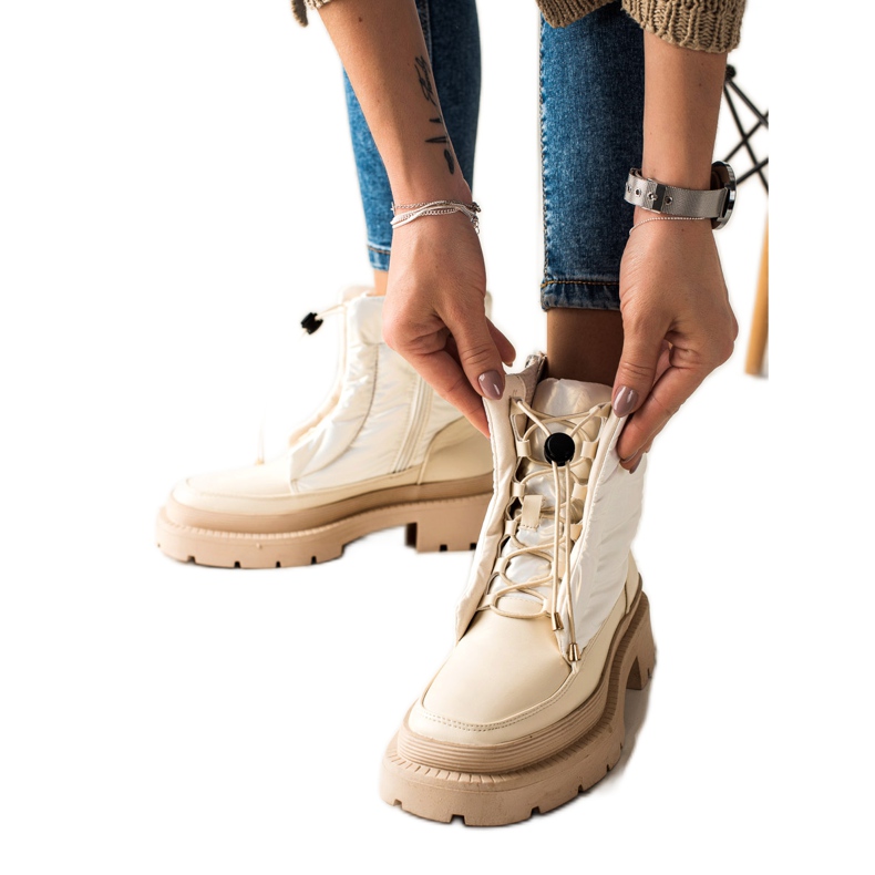 Small Swan Beiget lumisaappaat alustalla