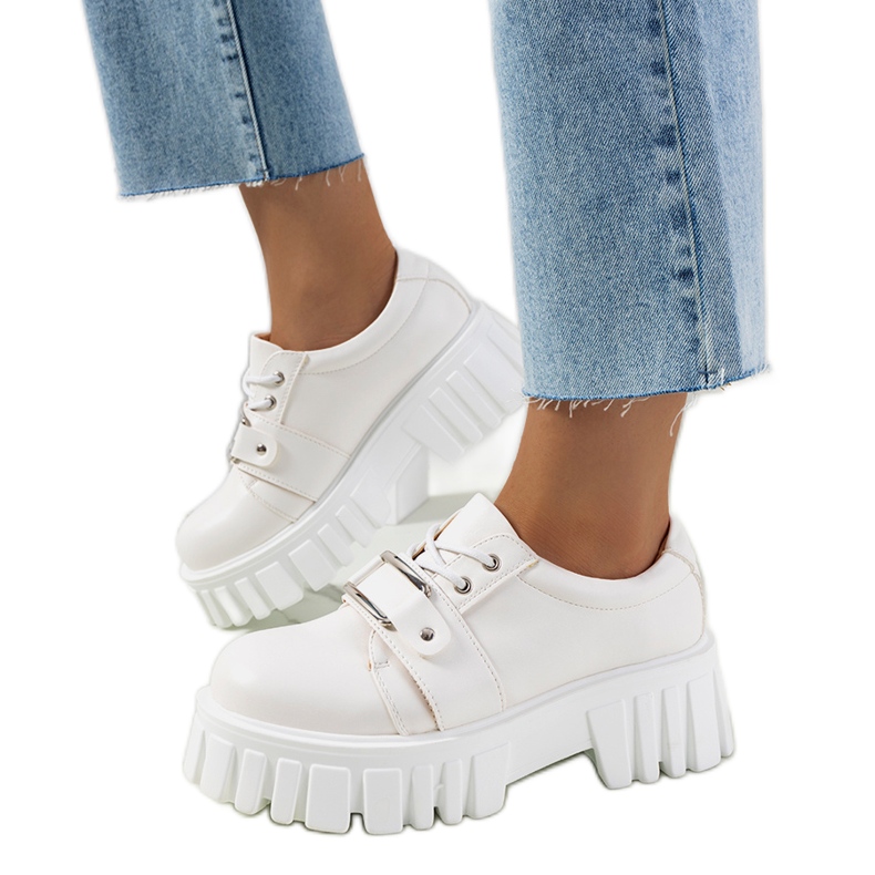 Sallien valkoiset kengät traktorin pohjassa valkoinen