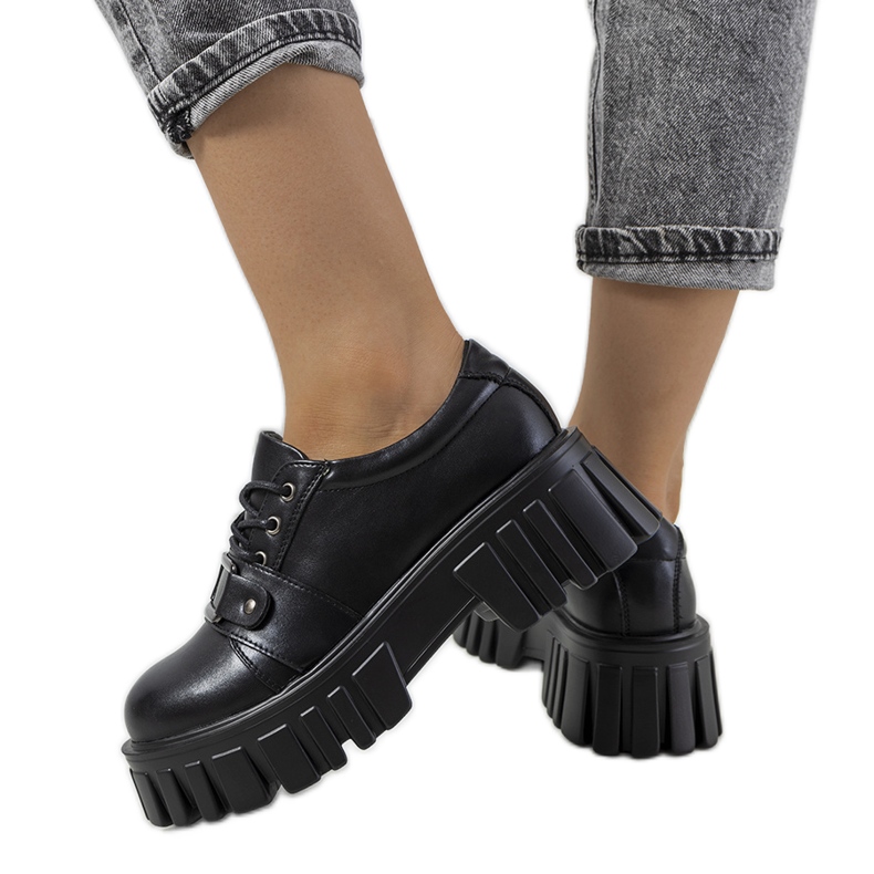 Sallien mustat kengät traktorin pohjassa