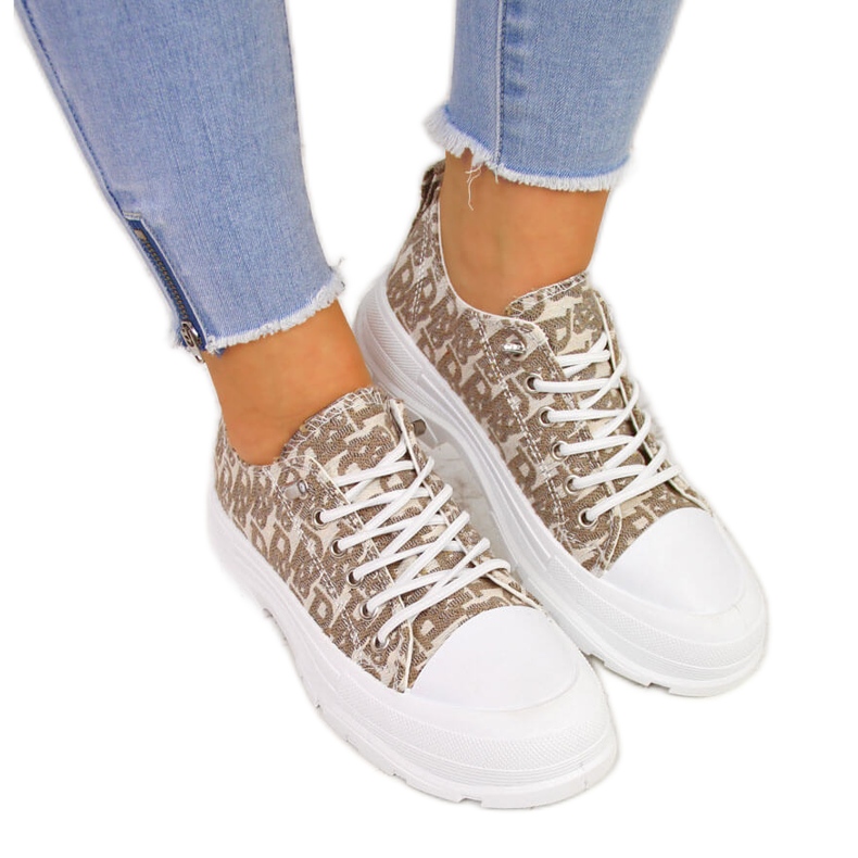 Naisten beigenväriset tennarit alustalla, jossa kirjoitukset Sabatina