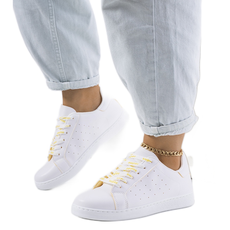 Kohon valkoiset ja keltaiset urheilukengät valkoinen