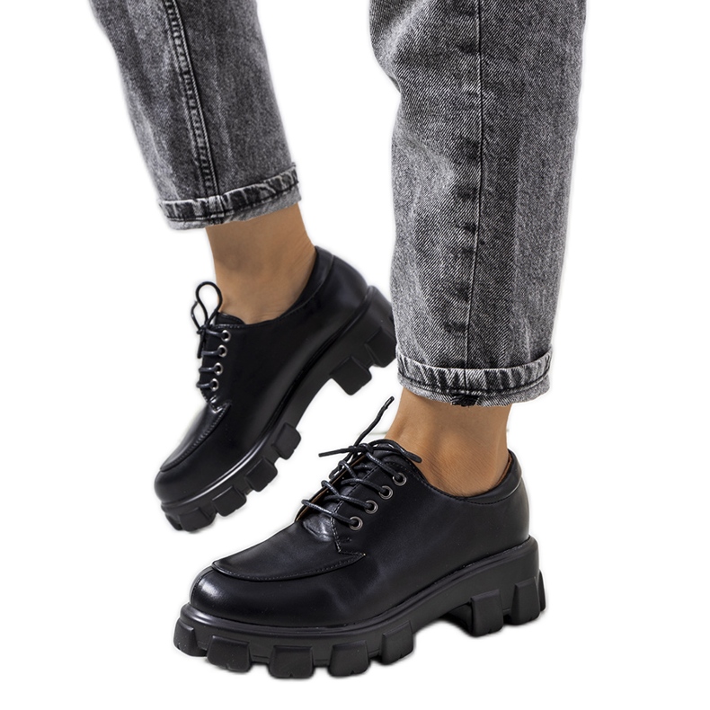 Mustat kengät Feline traktorin pohjassa