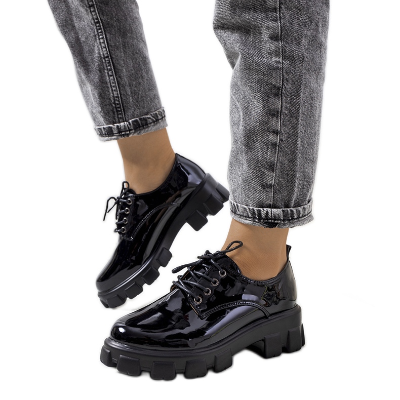 Mustat lakatut kengät traktorin pohjassa Wind