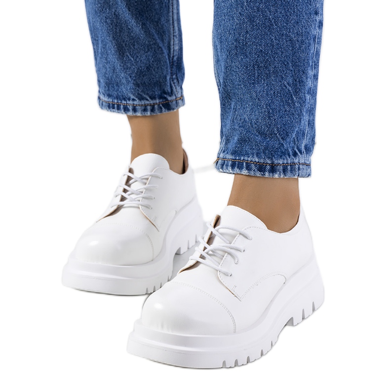 Hentan valkoiset kengät traktorin pohjassa valkoinen