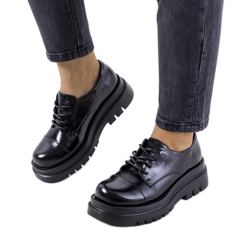 Hentan mustat kengät traktorin pohjassa