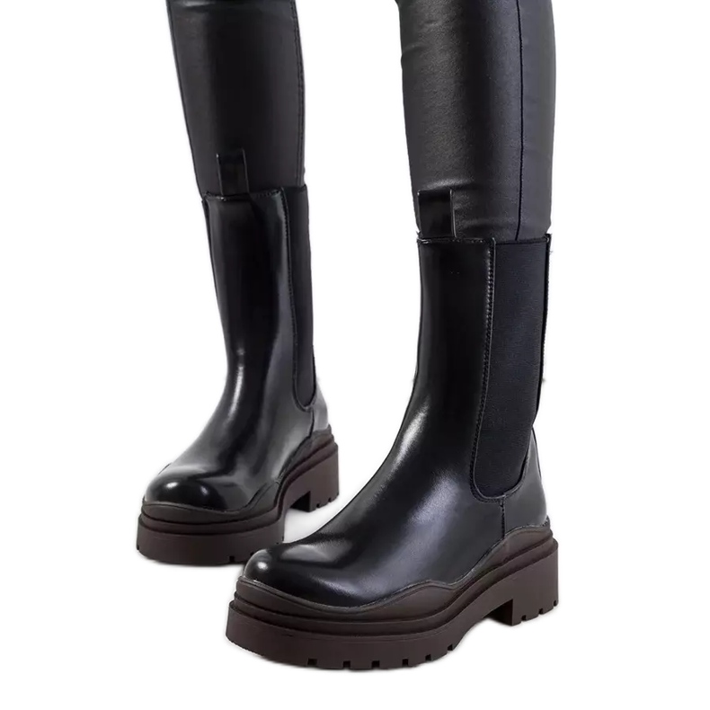 Mustat saappaat ruskealla Nester-pohjalla