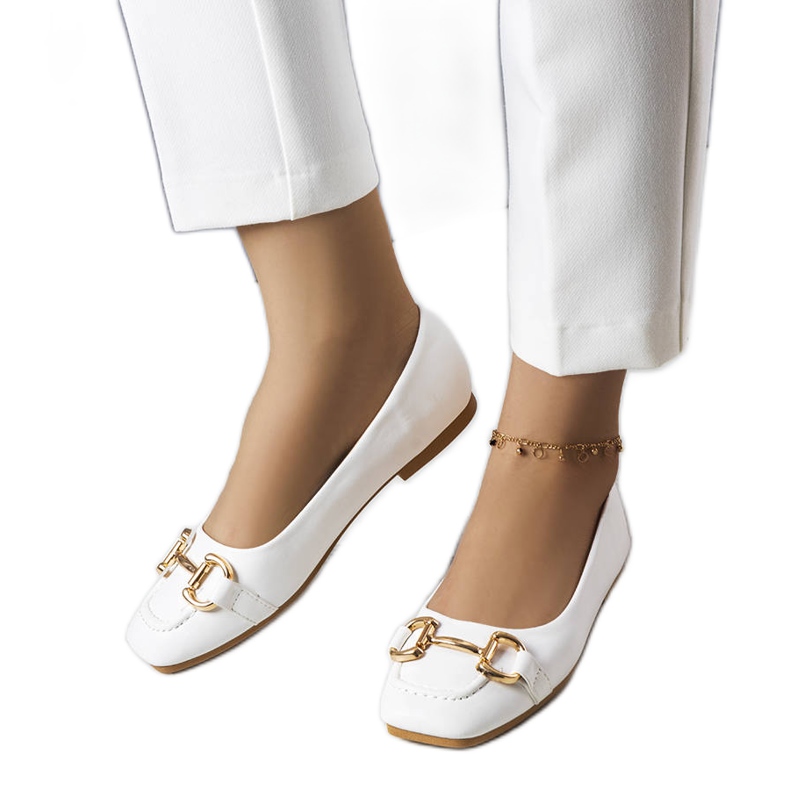 Valkoiset balerinat kultaisilla Iris-koristeilla valkoinen