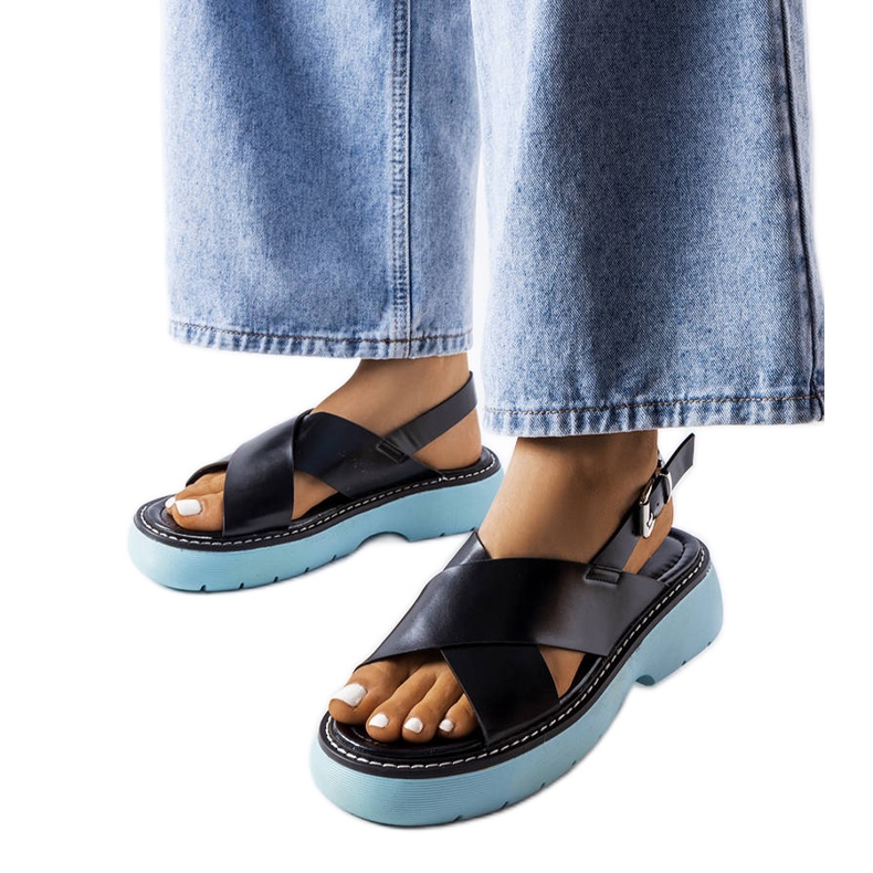 Rozanan mustat sandaalit sinisellä alustalla