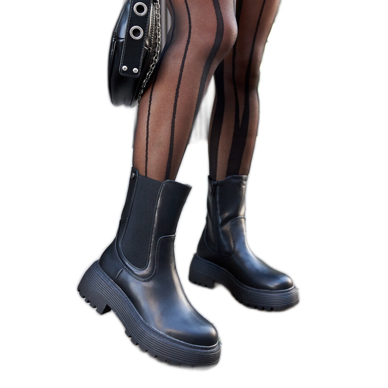 Mustat eristetyt saappaat alustalla