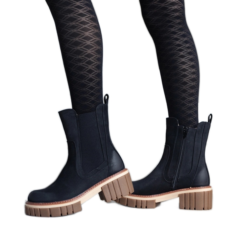 Shollan mustat massiiviset alustasaappaat, joissa hankausta