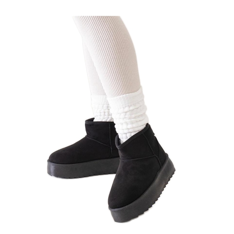 Mustat rennot lumisaappaat korkealla alustalla