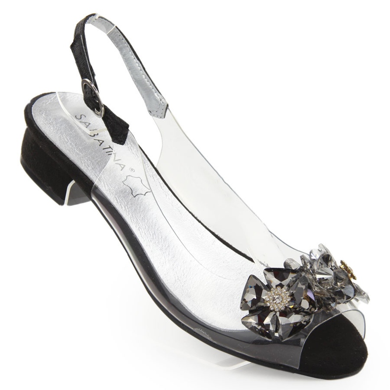 Sabatinan mustat läpinäkyvät litteät sandaalit kivillä