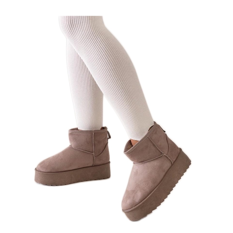 Tummanbeiget rento lumisaappaat korkealla alustalla