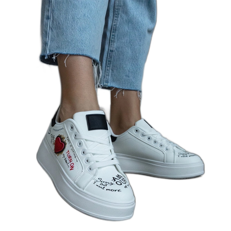 Valkoiset lenkkarit koristeltu laastari ja kirjoitukset alustassa valkoinen