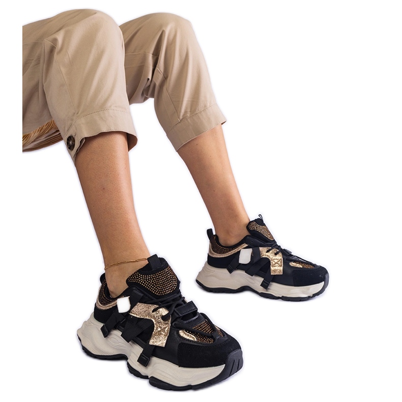 Mustat tennarit, joissa kullanväriset lisäkkeet