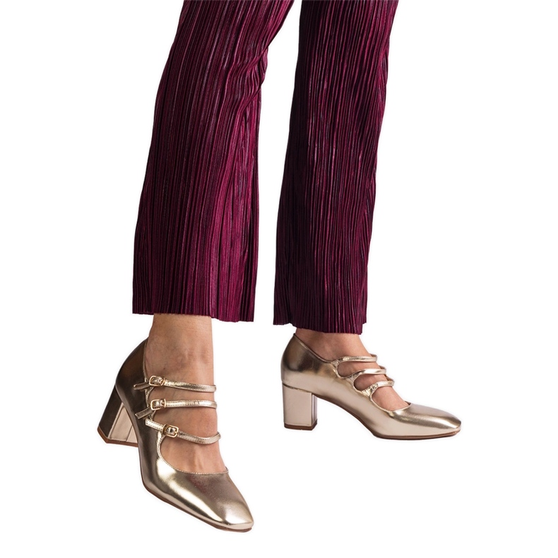 Kultaiset pumput postissa koristeellisilla solkilla kultainen