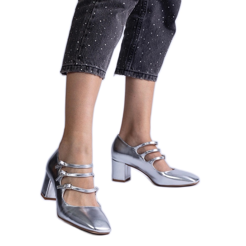 Hopeapumput pylväällä koristeellisilla metallisilla solkilla