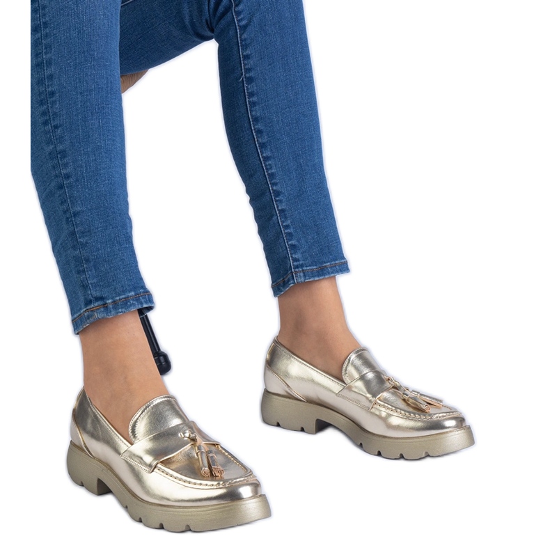 Kultaiset metalliset klassiset kengät reunoilla kultainen