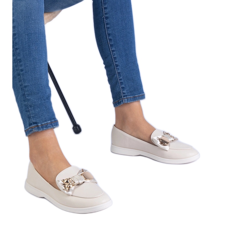 Beige -leivänkoristeet, jotka on koristeltu keulalla ja kultaisella nallekarhulla