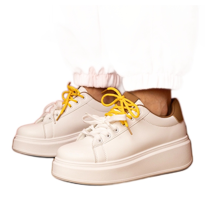 Valkoisenruskea urheilun lenkkarit laiturilla valkoinen