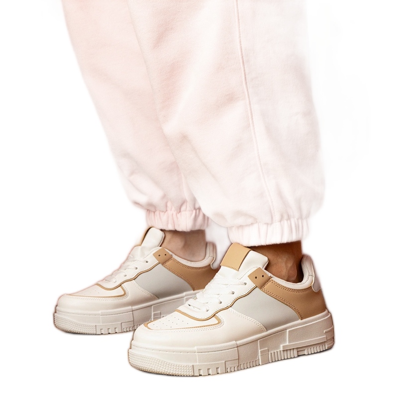 Valkoiset ja beige -urheilun lenkkarit Platfotmissa