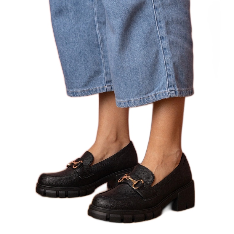 Mustat kengät matalassa pylväässä, jossa on kultainen sisustus