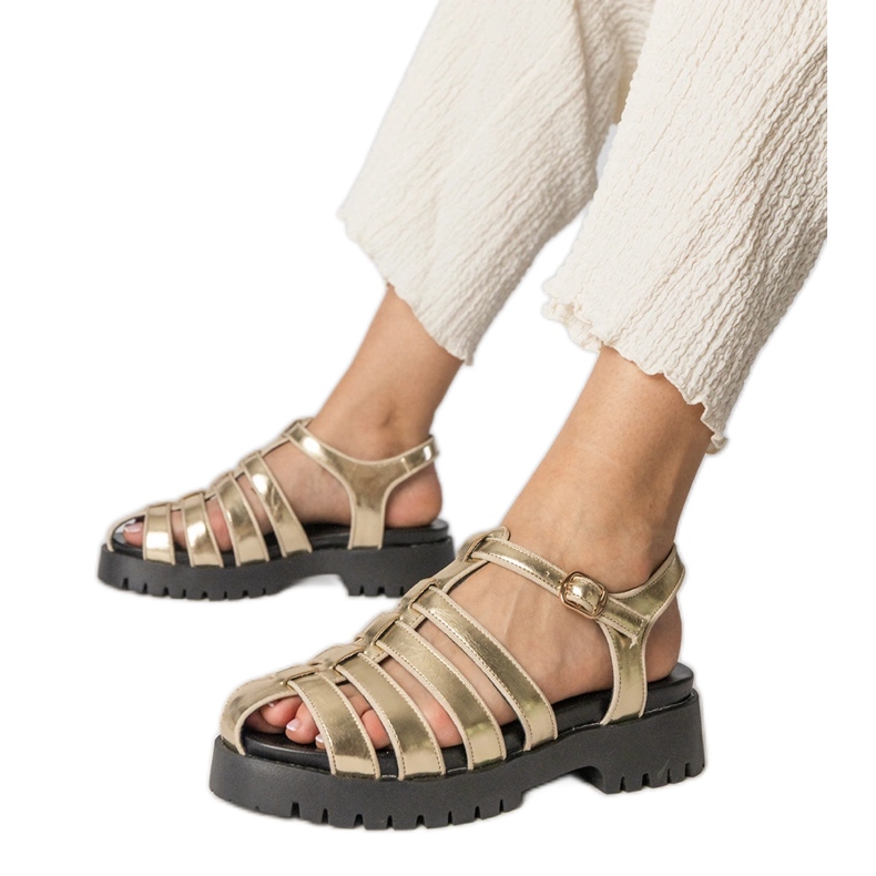 Kulta -sandaalit lavalla sormiviivalla rakennettu kultainen