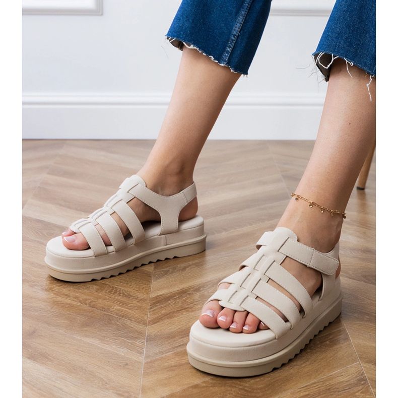 Beige gladiaattori sandaalit laiturilla