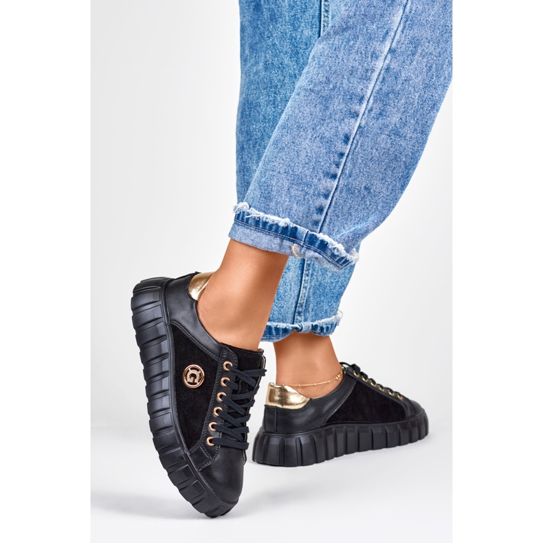 Mustat nahkaiset urheilukengät kultaisilla yksityiskohdilla 1