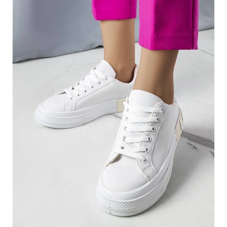 Valkoiset ja beigenväriset tennarit, joissa on Nora-kirjoitus 1