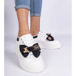 Mustat lenkkarit, jotka on koristeltu jousella ja kultaisella nallekarhulla 1