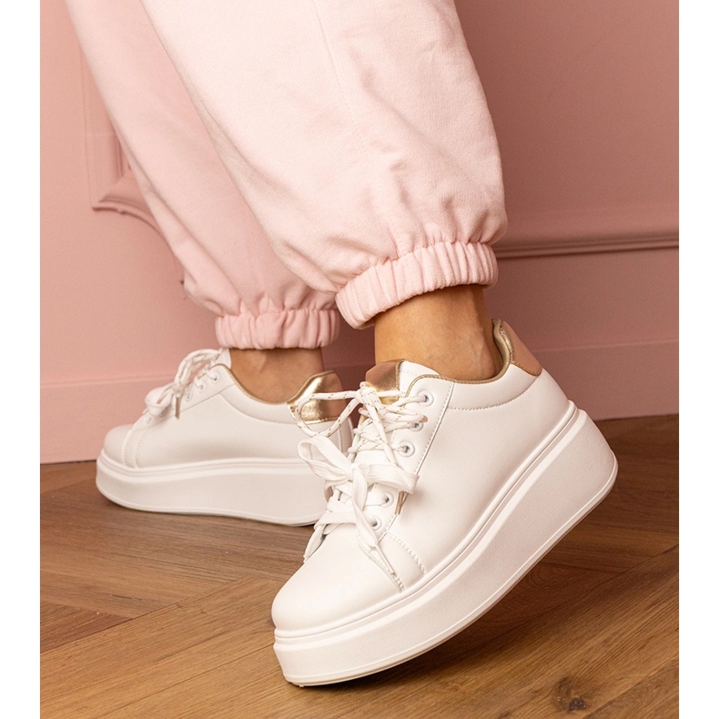 Valkoiset ja kultaiset urheilut lenkkarit laiturilla valkoinen 2