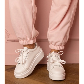 Valkoiset ja hopea -urheilut lenkkarit laiturilla valkoinen 1