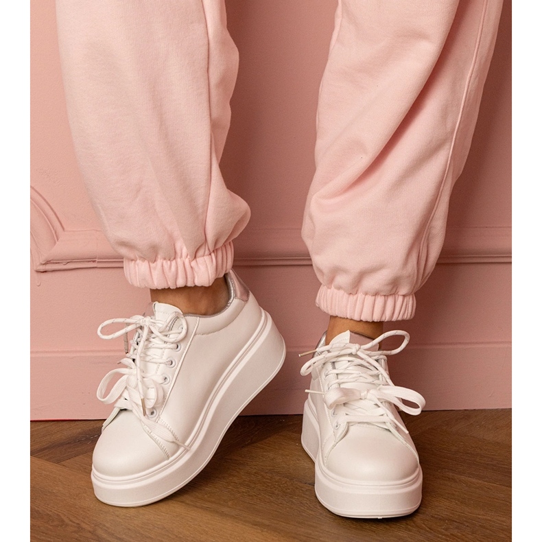 Valkoiset ja hopea -urheilut lenkkarit laiturilla valkoinen 1