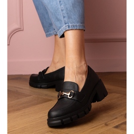 Mustat kengät matalassa pylväässä, jossa on kultainen sisustus 1