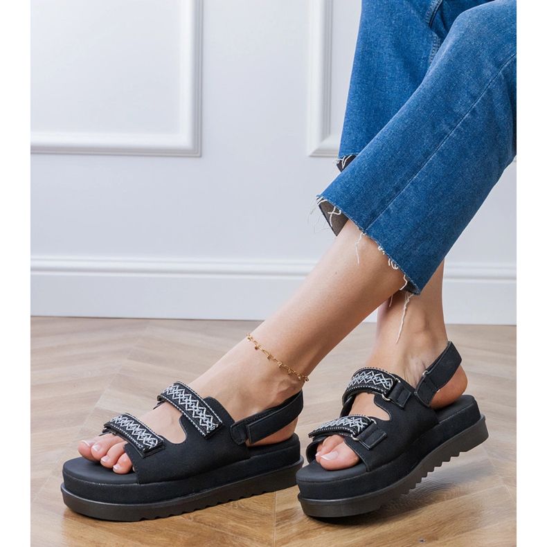 Mustat sandaalit, joissa on brodeeratut raidat laiturilla 2