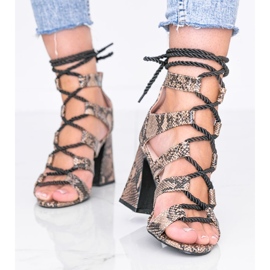 Iloinen käärmeen motiivi beigenvärisissä sandaaleissa 1